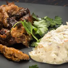 Saftigt pulled pork tid med krämig coleslaw, garnerat med färsk koriander. En klassisk kombination för en härlig måltid.