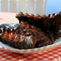 Grillade revben med en härlig glaze, serverade på en vit tallrik med amerikansk flagga.