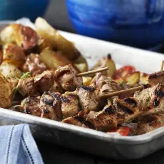 Grillade spett med fläskkött, rostade potatisar och citronklyftor. Perfekt med en god souvlaki krydda för extra smak.