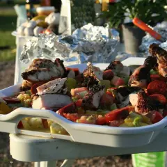 En stor vit form med grillad kyckling och en färgglad grönsakssallad, perfekt som salsa till grillat.