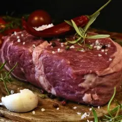 Rå entrecote, redo för grillen, med rosmarin, chili och vitlök. En perfekt grillad entrecote marinad väntar.