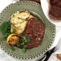 Pepparbiffar med potatisgratäng, grillad citron och persilja. En härlig måltid att grilla pepparbiff till.