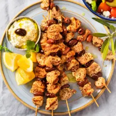 Grillade kycklingspett med oliver, citronklyftor och en krämig dipp. Perfekt för en somrig middag med smak av souvlaki marinad.