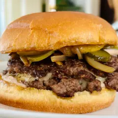 Dubbel hamburgare med smält ost, picklad gurka och karamelliserad lök. En touch av worcestershiresås ger extra djup.