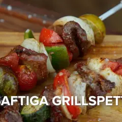 Saftiga grillspett med kött, grönsaker och citron på en träskärbräda. Perfekt för sommarens grillkvällar.