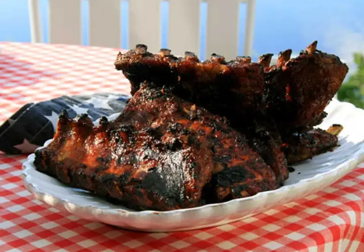 Grillade revben med en härlig glaze, serverade på en vit tallrik med amerikansk flagga.