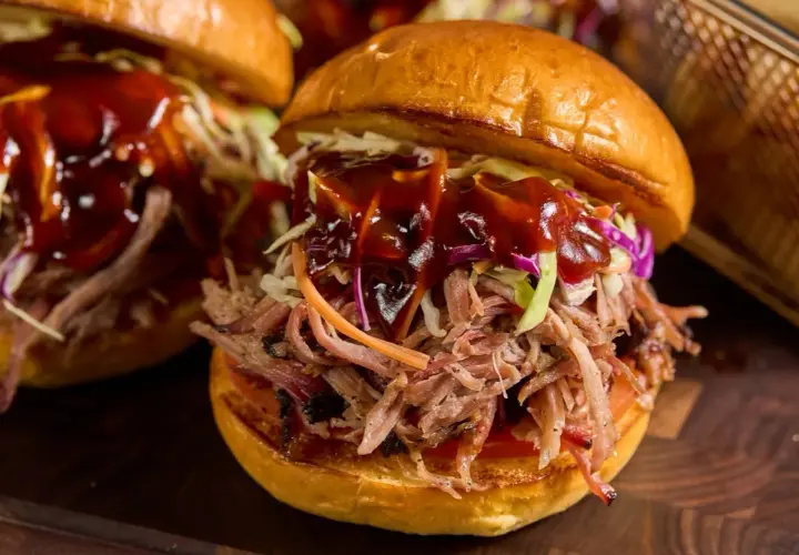 Saftig pulled pork-burgare med krispig coleslaw och en generös klick BBQ-sås. Perfekt sås till pulled pork!