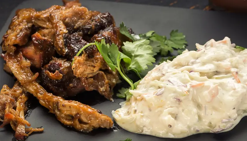 Saftigt pulled pork tid med krämig coleslaw, garnerat med färsk koriander. En klassisk kombination för en härlig måltid.