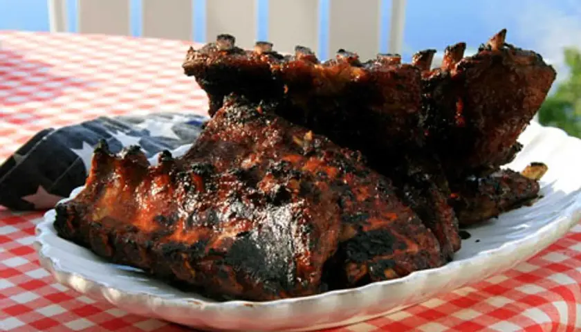 Grillade revben med en härlig glaze, serverade på en vit tallrik med amerikansk flagga.