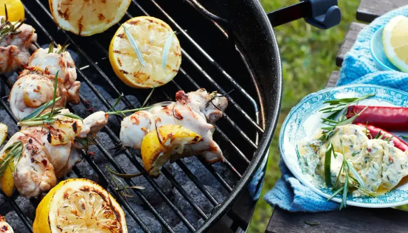 Grillade kyckling drumsticks med citron och rosmarin. En tallrik med en krämig röra, chili och rosmarin står bredvid.