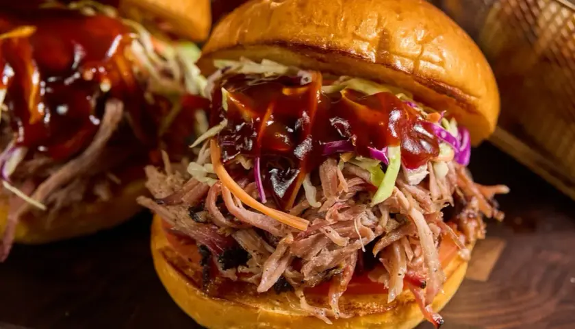 Saftig pulled pork-burgare med krispig coleslaw och en generös klick BBQ-sås. Perfekt sås till pulled pork!