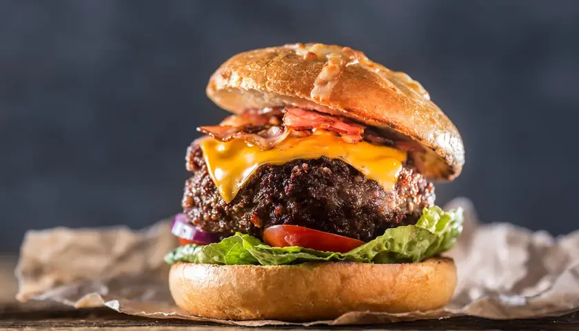 En saftig hamburgare med smält ost, krispigt bacon och färska grönsaker. En riktig hamburgare smet som får det att vattnas i munnen.
