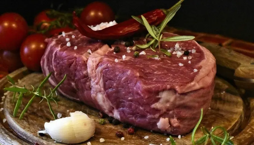 Rå entrecote, redo för grillen, med rosmarin, chili och vitlök. En perfekt grillad entrecote marinad väntar.