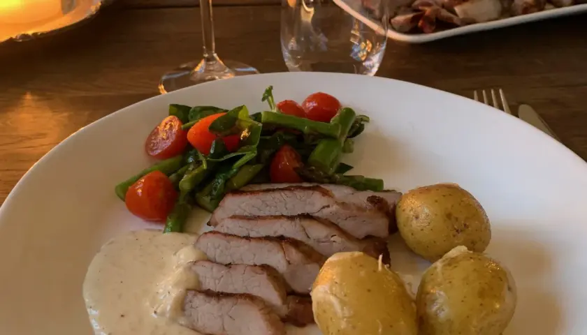 Skivad fläskfilé med krämig sås, sparris, körsbärstomater och småpotatis. Perfekt pluma innertemperatur för en lyckad middag.