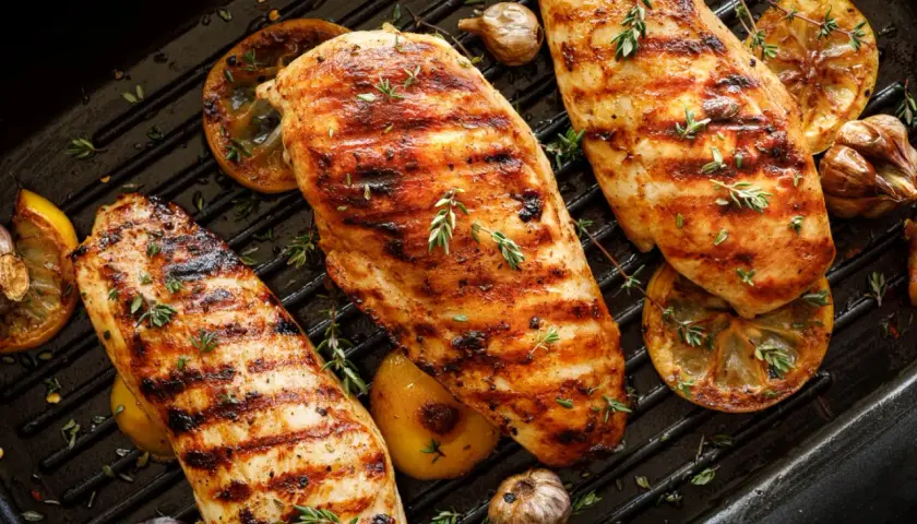 Grillade kycklingbröst med citron och vitlök på en grillpanna. Perfekt för att grilla kycklingvingar en solig dag.