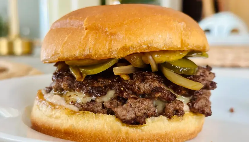 Dubbel hamburgare med smält ost, picklad gurka och karamelliserad lök. En touch av worcestershiresås ger extra djup.