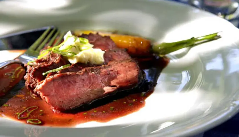 Skivat flat iron steak recept med potatismos och en grön kvist.