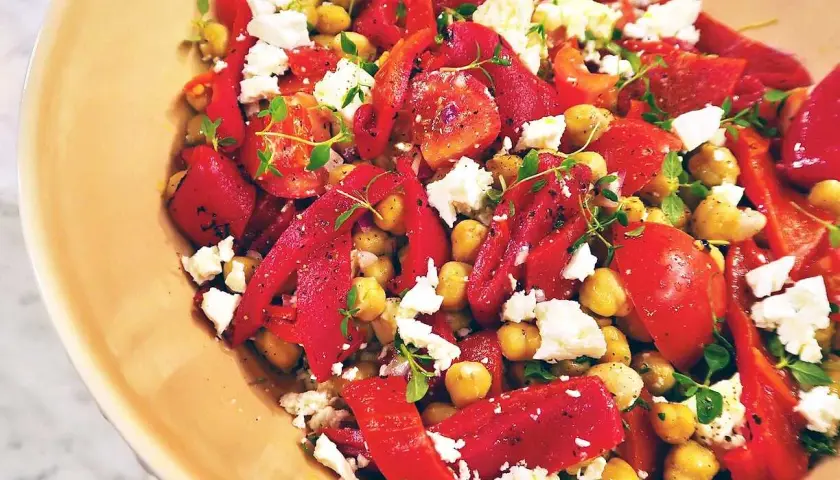 En skål med kikärtor, röd paprika och fetaost, toppad med färska örter. En härlig paprika salsa som passar till det mesta.