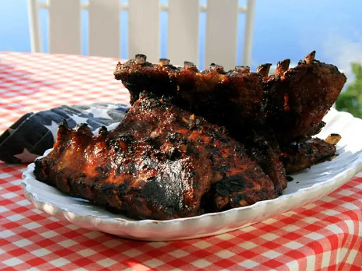 Grillade revben med en härlig glaze, serverade på en vit tallrik med amerikansk flagga.