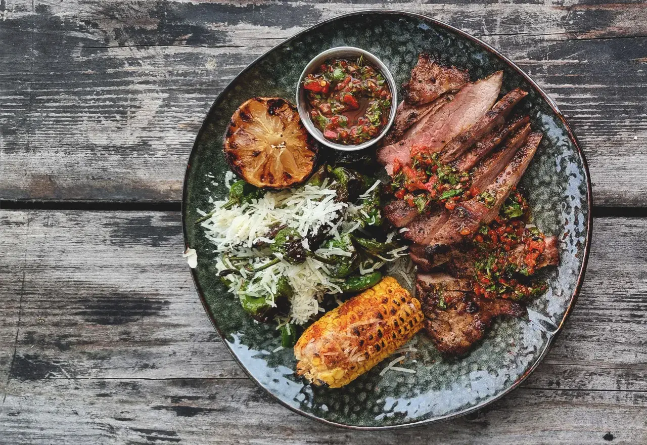 En tallrik med saftigt grillat secreto iberico, serverat med grillad majskolv, citron och en fräsch salsa. Ett perfekt secreto iberico recept för en festmåltid.