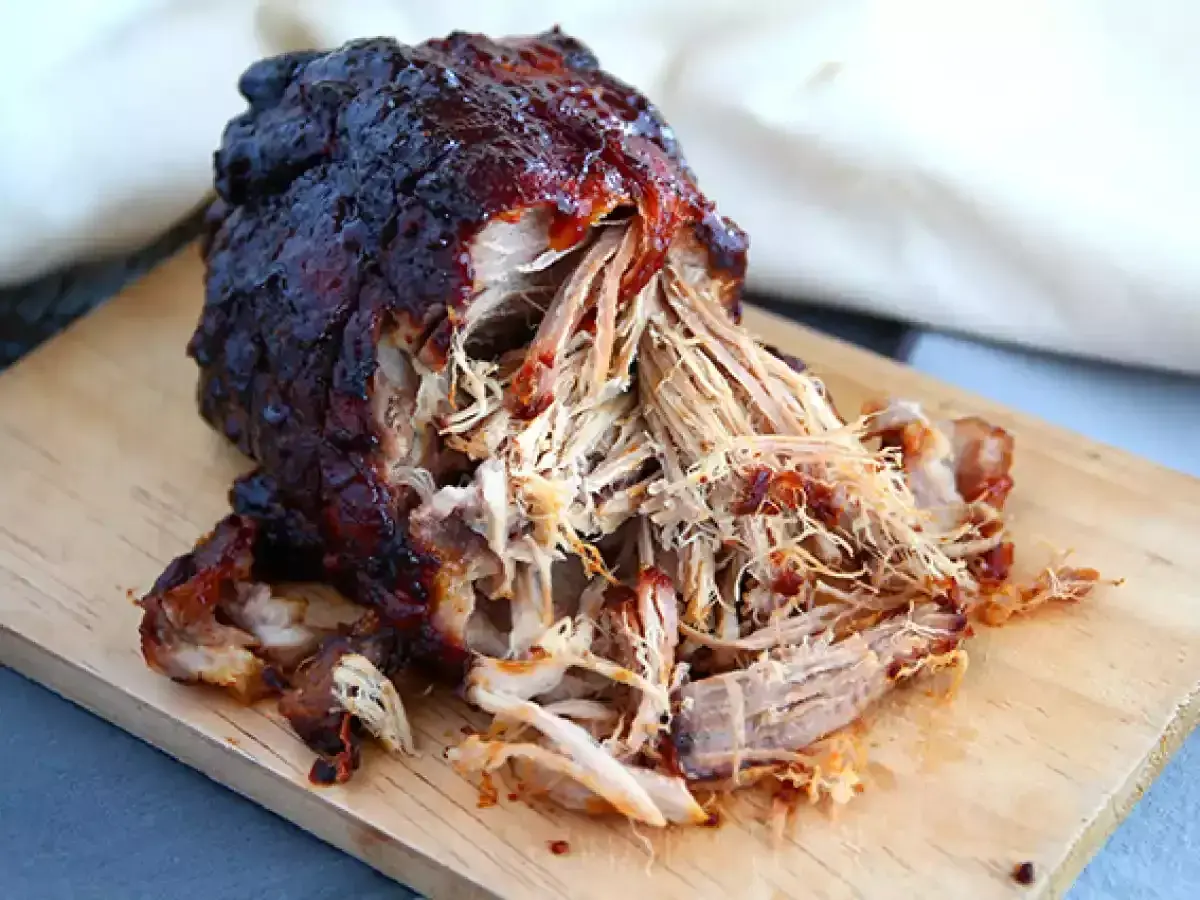 Saftigt, mörkt pulled pork på en skärbräda. Perfekt temperatur för att dra isär köttet.