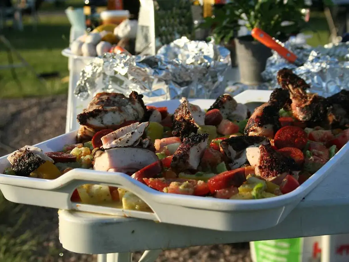 En stor vit form med grillad kyckling och en färgglad grönsakssallad, perfekt som salsa till grillat.