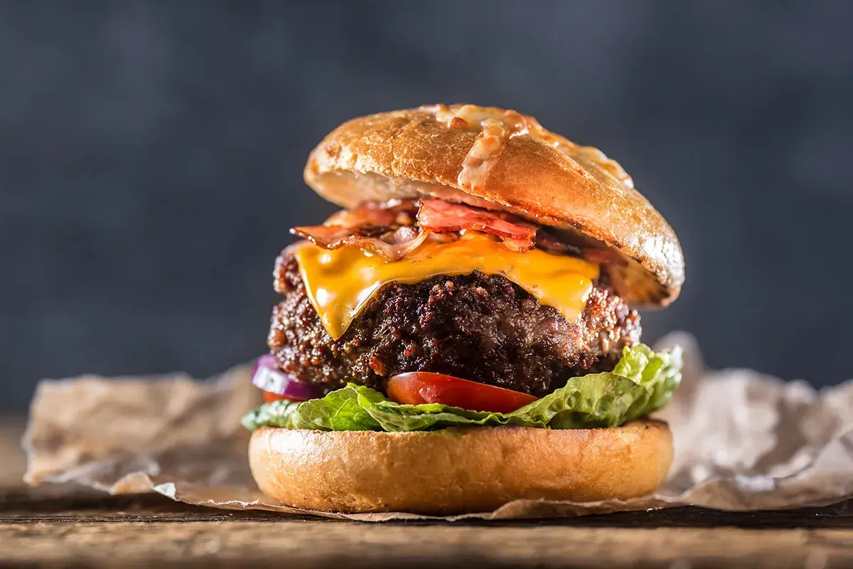 En saftig hamburgare med smält ost, krispigt bacon och färska grönsaker. En riktig hamburgare smet som får det att vattnas i munnen.