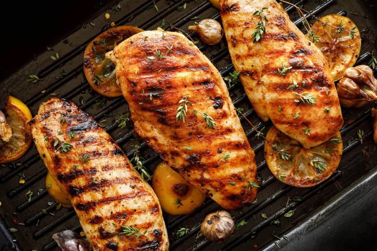 Grillade kycklingbröst med citron och vitlök på en grillpanna. Perfekt för att grilla kycklingvingar en solig dag.