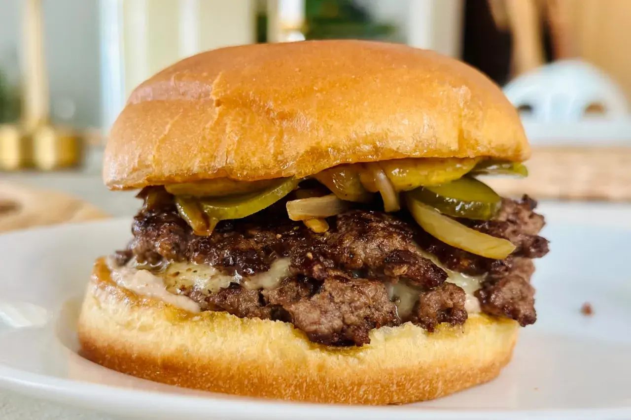 Dubbel hamburgare med smält ost, picklad gurka och karamelliserad lök. En touch av worcestershiresås ger extra djup.