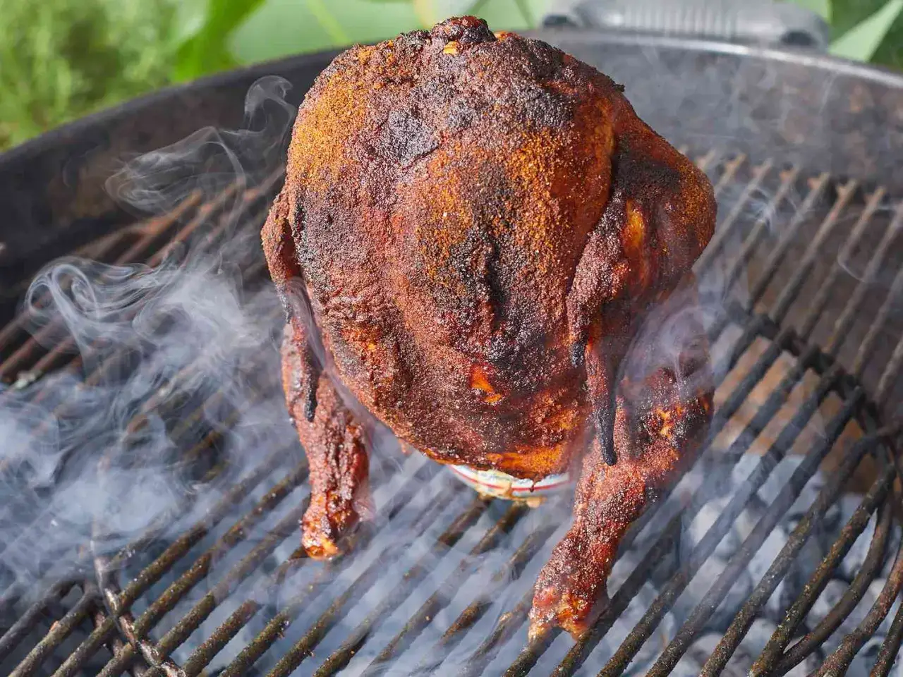 En saftig &ouml;lkyckling ryker p&aring; grillen, redo att serveras.