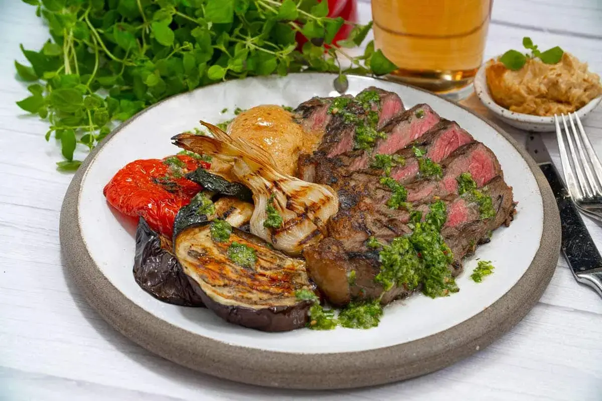 Saftig picanha med perfekt innertemperatur, serverad med grillade gr&ouml;nsaker och en gr&ouml;n s&aring;s.