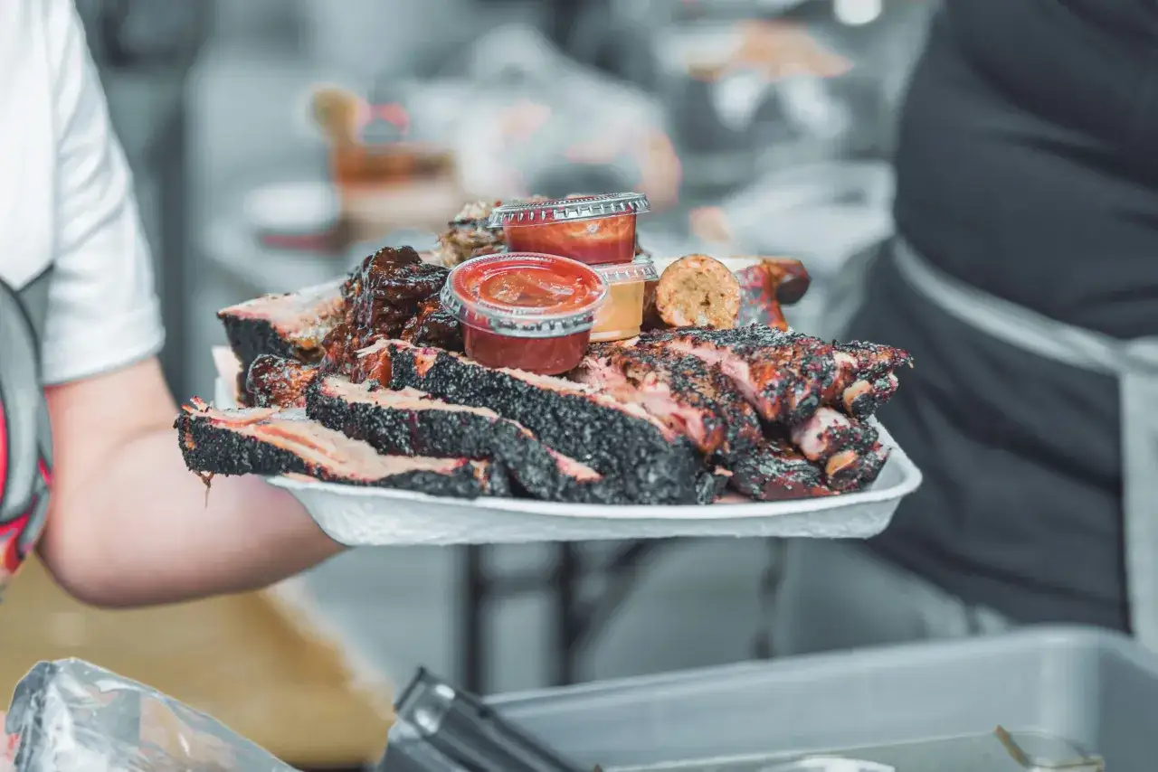 En bricka med saftiga revbensspj&auml;ll och brisket, perfekt f&ouml;r en &auml;kta texas bbq-upplevelse. Serveras med olika s&aring;ser.