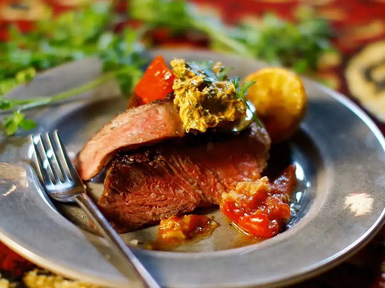 Perfekt grillad wagyu-biff med en klick örtsmör, serverad med rostade tomater och en potatis. En dröm för alla som älskar att grilla wagyu.