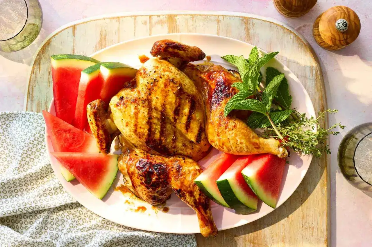 Helstekt kyckling med grill glaze, serverad med saftiga vattenmelonklyftor och färska örter. En perfekt sommarrätt.
