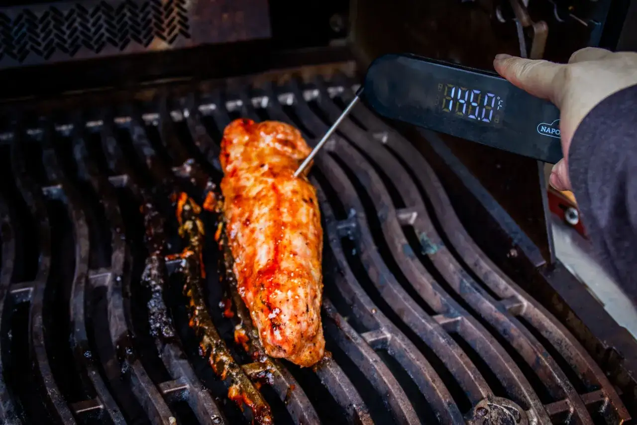Grilla vildsvin ryggbiff p&aring; grillen, en termometer visar temperaturen.