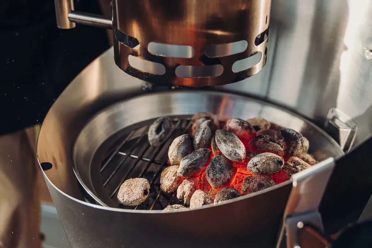 Gl&ouml;dande kol i grillen, redo f&ouml;r grillkv&auml;llen. Fr&aring;gan &auml;r hur mycket kol i grillen som beh&ouml;vs f&ouml;r perfekt resultat.