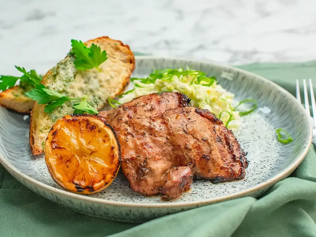 Grillad kyckling med perfekt temperatur, serverad med vitl&ouml;ksbr&ouml;d, citron och fr&auml;sch sallad.