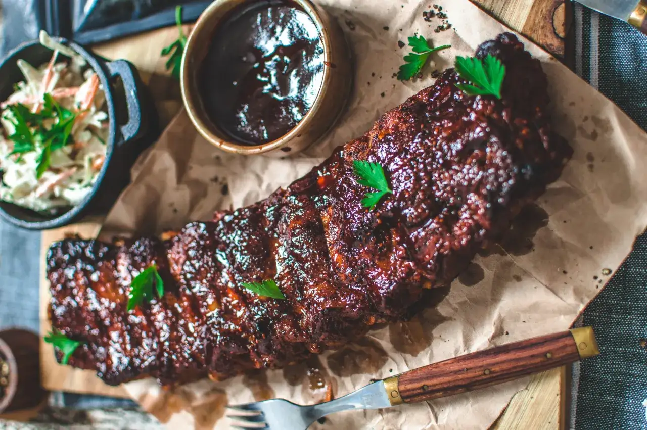 Glacerade revben, redo att grillas, serveras med BBQ-s&aring;s och coleslaw. Att koka revben innan grillning ger extra saftighet.
